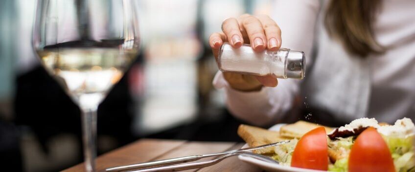 Frau salzt ihr Essen 