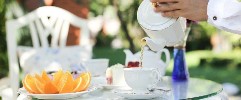 Mann schenkt Tee ein mit einer Gastronomie-Teekanne